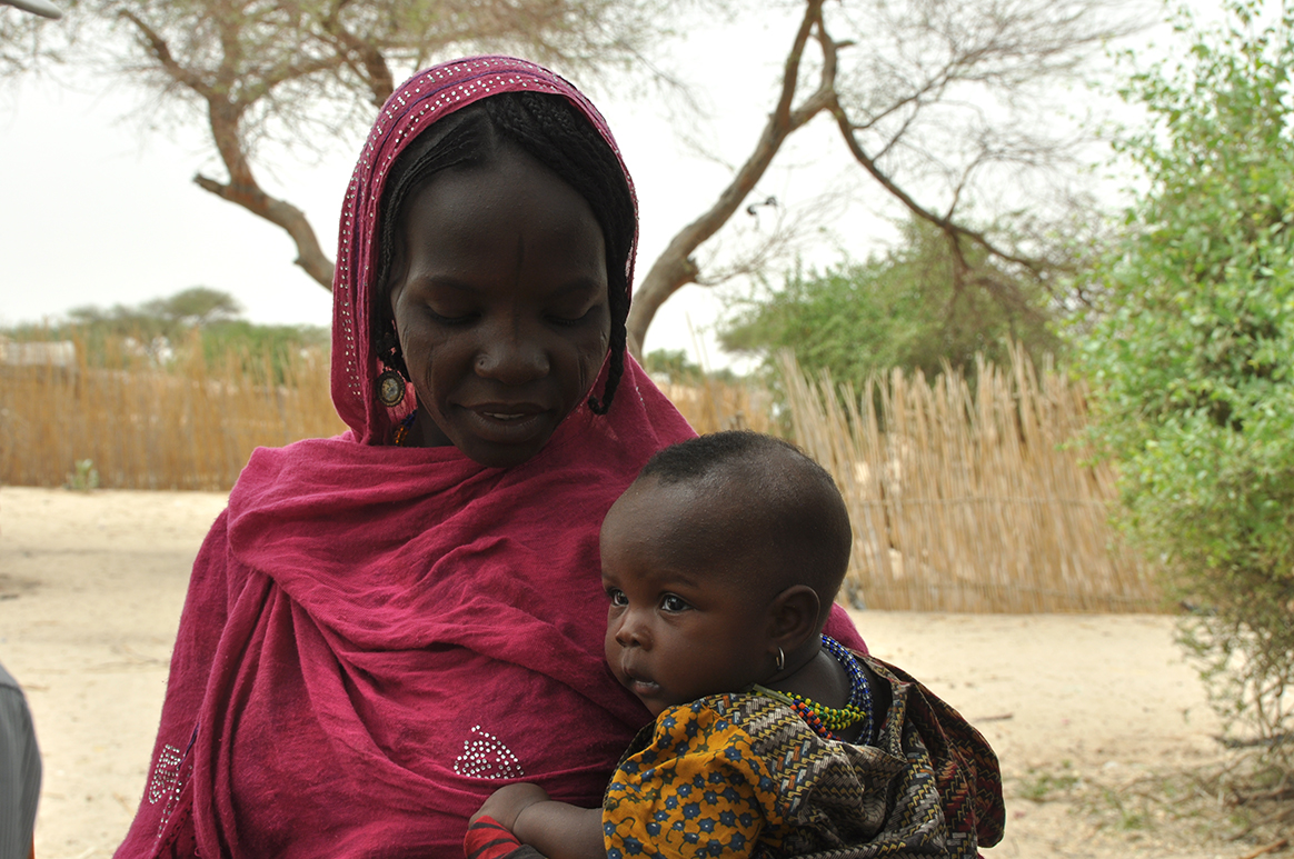 A mother and her child wait for routine immunization services in Mélea camp for internally displaced persons. © WHO/D. Levison