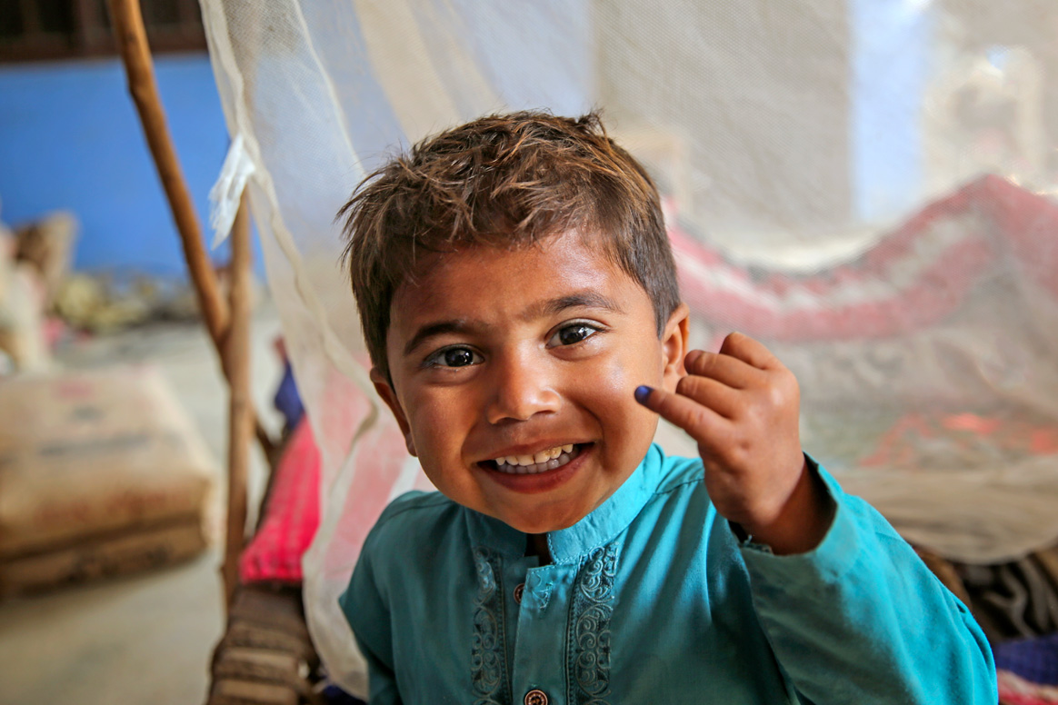 The indelible purple ink on the finger means that two-year Rajesh is protected against polio. © WHO Pakistan/ Asad Zaidi.